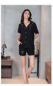 Détail de pyjama noir en modal avec bords à volants et broderie de cœur sur le haut court