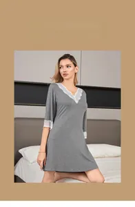 Detail of elegant V-neck grey nightdress with white lace trim and modal cotton fabric