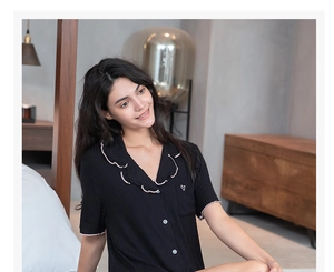 Détail du haut de pyjama en modal à manches courtes avec bord rose et broderie de cœur