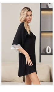 Close-up of wide white lace patchwork on the sleeves of a black modal cotton nightgown
