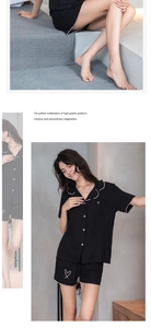 Détail d'un pyjama en modal noir avec bordure rose ondulée et broderie de cœur