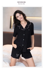 Détail de pyjama en modal noir avec bordure rose ondulée et broderie de cœur délicate