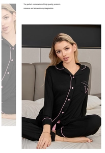 Gros plan d'un pyjama en modal noir avec passepoil rose et broderie V sur la poche