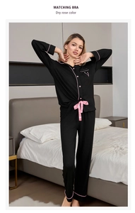 Détail de pyjama rayé noir en modal avec passepoil rose contrasté et nœud en satin élégant