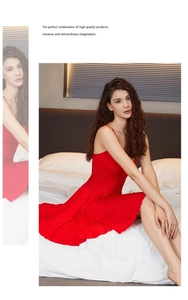 Détail d'une nuisette rouge en maille avec ourlet à volants et fines bretelles sur le lit