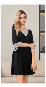 Detailed view of elegant white lace stitching on V-neck and sleeves of black nightdress