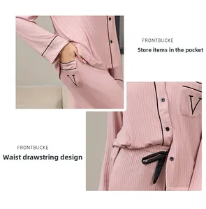 Détail du pyjama à rayures roses montrant les boutons, la poche brodée et le lien à la taille