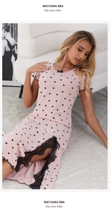 Détail de chemise de nuit rose avec motifs cœurs, nœud noir et fente en dentelle