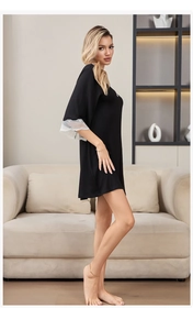 Detailed close-up of delicate white lace trim on a black modal cotton nightgown sleeve