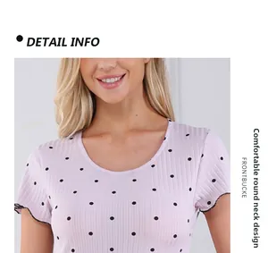 Détail du col rond et de l'imprimé pois sur le tissu rose de la chemise de nuit