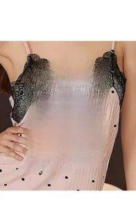Détail du caraco rose à pois avec bordure en dentelle noire et texture coton côtelé