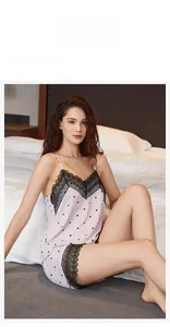 Détail de pyjama caraco à pois avec dentelle noire sur le décolleté en V et le short