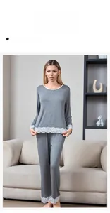 Close-up of elegant white lace trim on the hem of gray modal cotton pajama set for women