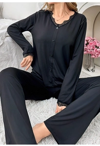 Détail du pyjama noir à col en V avec bordure en dentelle délicate et boutonnage sur le devant