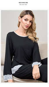 Close-up of elegant white lace trim on the sleeve cuff of black modal cotton pajamas