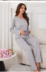 Detail of grey knit pajama set with V-neck button top and pants on a relaxing model