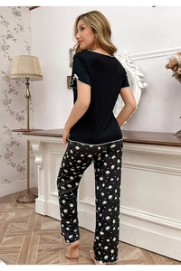 Détail du haut de pyjama en maille avec liseré contrasté et nœud blanc sur la manche