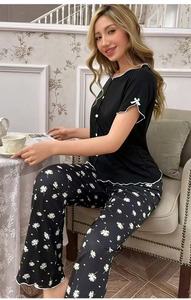 Détail du haut de pyjama en maille noire avec bordure festonnée et pantalon marguerite