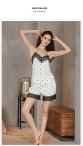 Pyjama à pois avec bordure en dentelle présenté sur un mannequin dans une chambre