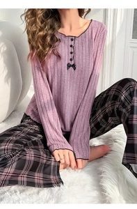 Detail des lavendelfarbenen gerippten Langarmshirts mit Knöpfen und Schleife