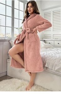 Dettaglio dell'accappatoio in peluche rosa con morbida trama in pile e cintura in vita