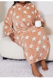 Cozy pink flannel hooded blanket with star print worn by model on a sofa
