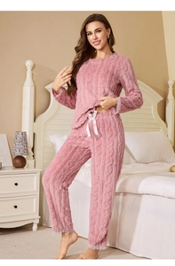 Detail of pink coral fleece pajamas with cable knit texture and white lace trim