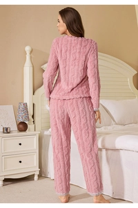 Close-up of pink coral fleece pajamas set with cable knit texture and white lace edges