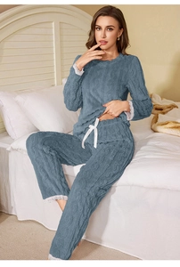 Detail of coral fleece pajamas with cable knit texture and white lace trim at the hem