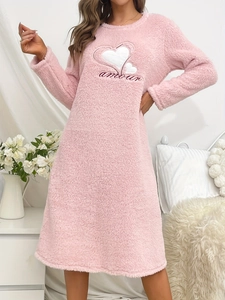 Détail de la chemise de nuit rose en polaire avec cœur brodé et texte amour blanc