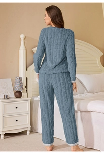Detail of greyish blue coral fleece pajamas with elegant white lace cuffs in a bedroom
