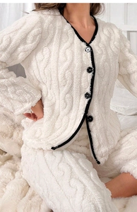 Dettaglio della trama a treccia sul completo loungewear in pile bianco con bottoni neri