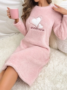 Détail du vêtement de nuit en polaire rose avec broderie cœur et texte amour