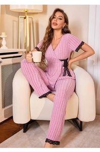 Detail of pink ribbed lounge set featuring delicate black lace trim and bow accents
