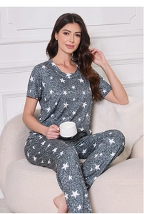 Close-up of star print short sleeve pajama top and matching pants on a soft sofa