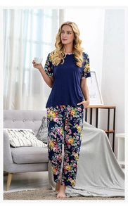 Detail von marineblauem Pyjama-Oberteil mit Blumenbündchen und passender gemusterter Hose