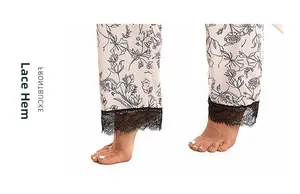 Detailed view of beige floral pajama pants featuring elegant black lace trim at the hem