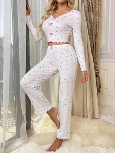 Detail of white rib-knit pajama set with pink heart print, ruffles and bow accents