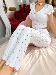 Detail of V-neck heart print loungewear with pink bow accents and lettuce edge trim
