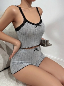 Close-up of gray ribbed pajama set with delicate black lace trim and bow details