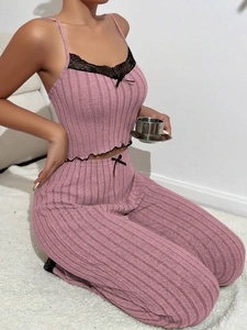 Detail of pink ribbed lounge set featuring delicate black lace trim and bow accents