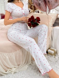 Detail of ribbed pajama set featuring pink hearts, lace ruffles and bow accents