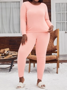 Femme en ensemble pyjama thermique rose doux dans un décor extérieur sous la neige