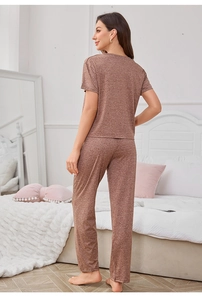 Close-up of melange brown-red knit pajamas fabric and loose fit design on a bed