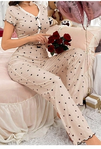 Detail of soft ribbed knit texture on cream pajama set with black heart prints