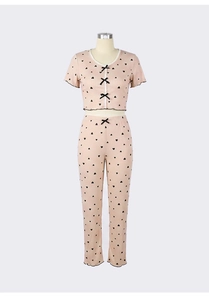 Detail of pink heart print loungewear featuring lace trim and small black bows decoration