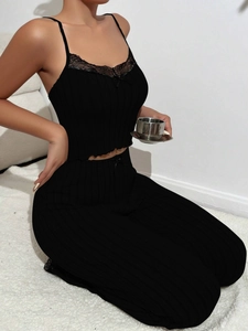 Detailed view of black rib-knit sleepwear set with delicate lace trim and bow on the camisole