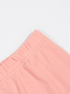 Détail macro de la taille élastique et du tissu en maille rose avec coutures à double aiguille