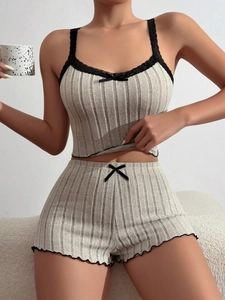 Detail of grey ribbed pajama set featuring black lace trim and bow accents