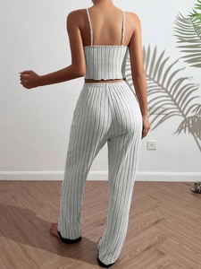 Rear view of woman in light gray ribbed pajama set featuring camisole and long pants